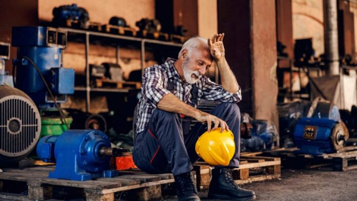 worker feeling stressed with yellow helmet